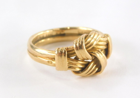 A knot ring, the central ship knot design on two layers, on a two row band, yellow metal possibly marked 18ct but rubbed, ring size J, 4.9g.