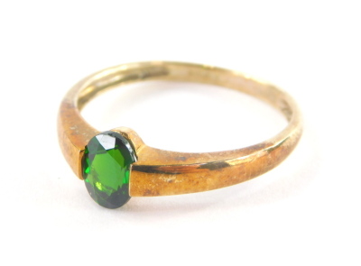 A 9ct gold dress ring, with central tension set emerald, the band marked QVC, ring size S, 2g all in.