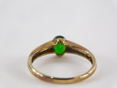 A 9ct gold dress ring, with central tension set emerald, the band marked QVC, ring size S, 2g all in. - 2