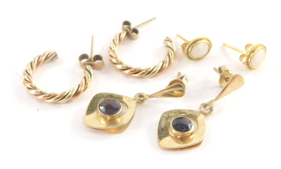 Three pairs of 9ct gold earrings, to include a pair of 9ct gold bi-colour hoop earrings, 1.5cm high, a pair of 9ct gold opal stud earrings, and a pair of 9ct gold and garnet set drop earrings, 7.4g all in. (3 pairs )