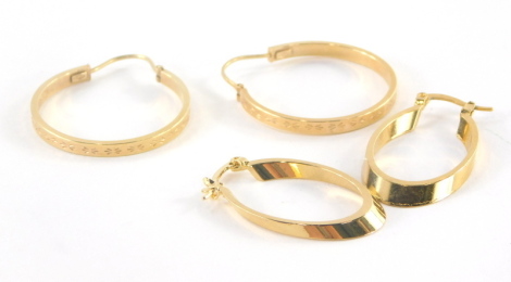 Two pairs of hoop earrings, to include a pair of 9ct gold large hoop earrings, each with etched detailing, 2.5cm wide, 2.6g all in, together with a pair of gold plated hoops. (2)