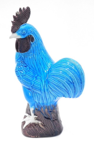 A Chinese turquoise and purple glazed porcelain model of a cockerel, impressed mark to underside, (AF), 31cm high.