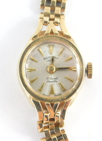 A Rotary 9ct gold ladies wristwatch, with small silver coloured circular dial, 1.2cm wide, on a three row 9ct gold bracelet, with safety chain, 14.1g all in, boxed.