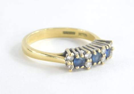 An 18ct gold sapphire and diamond set dress ring, set with three oval cut sapphires and six round brilliant cut diamonds, each in a raised platinum claw setting with pierced shoulders on a 18ct gold band, ring size P, 4.1g all in, boxed.