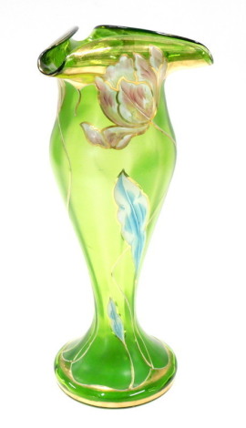 A late 19th/early 20thC green iridescent glass vase in the manner of Loetz, decorated overall with flowers and leaves in raised coloured enamels, the top of triangular form above a baluster column and a domed foot, 33cm high.