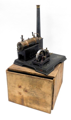 An early 20thC tin plate static engine, modelled with a brass and copper cylinder, ebonised and brass fittings, on a rectangular base with original pine box, in the manner of Marklin, 28cm wide.