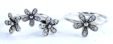 Two Pandora silver dress rings, one silver cluster ring, set with white crystals, ring size K, and a three group cluster floral ring, ring size K, 3.9g all in. (2, with one box)