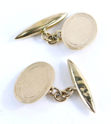 A pair of 9ct gold cufflinks, with oval engine turned shield, with curb link chain on bar backs, 4.8g.