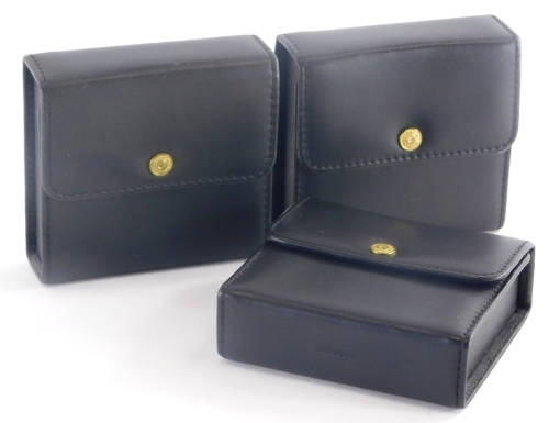 Three Coach black leather cases, with press stud openings, 11cm high, 11cm wide, 4cm deep.