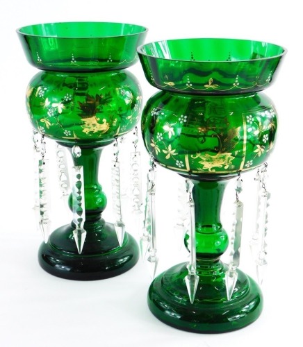 A pair of Victorian green glass table lustres, with gilt highlights, and various drops, 33cm high.