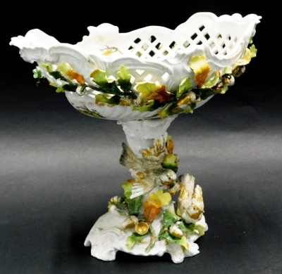 A late 19thC Sitzendorf two handled pedestal bowl, the bowl with pierced decoration, and decorated with leaves, acorns, etc., the base decorated with birds, leaves, acorns, etc. 28cm high.