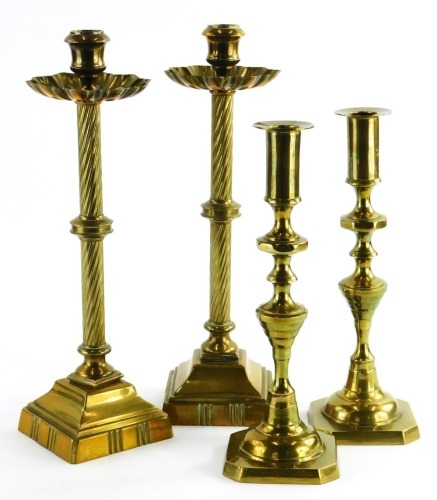 A pair of 19thC brass candlesticks, with a flare shaped drip tray, twisted stems, on square pedestal bases, 33cm high, and another pair of brass candlesticks.