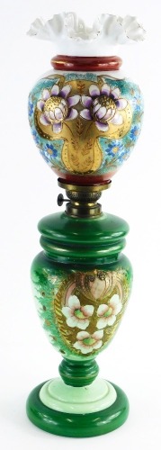 A Victorian opaque glass oil lamp, decorated with an arrangement of flowers, leaves, etc., 55cm high.