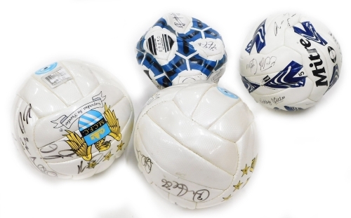 Two Manchester City signed footballs, and two others.