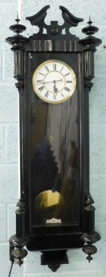 A late 19thC ebonised Vienna wall clock, with a white enamel dial, 114cm high.