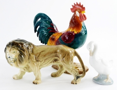 A Beswick figure of a leghorn cockerel, number 1892 and a ceramic lion figurine and a nao goose. (3)