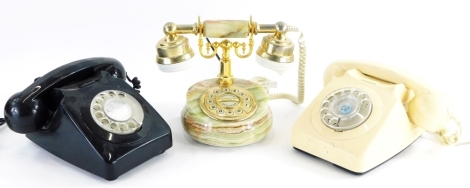 A collection of three vintage telephones, in ivory, black and onyx.