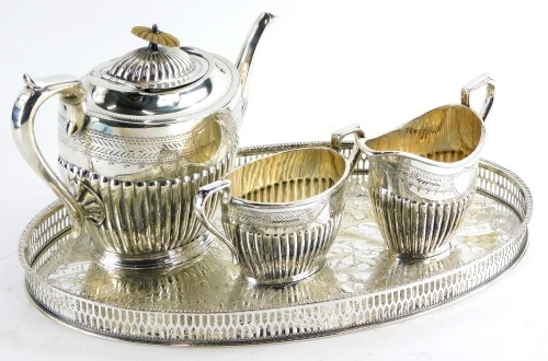 A silver plated part fluted three piece tea set, and an oval galleried tray. (4)