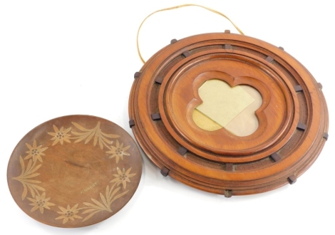 A Victorian walnut frame, modelled in the form of a ships wheel, with a quatrefoil shaped mount, 41cm diameter, and a Black Forest plate, decorated with Edelweiss flower.