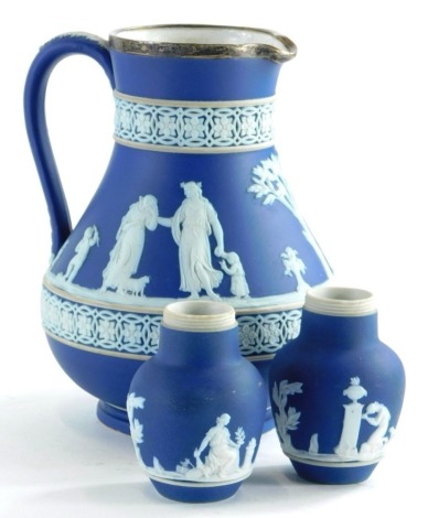 A Wedgwood dark blue Jasperware jug, with silver mount, (AF), and a pair of Adams dark blue Jasperware vases. (3)