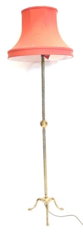 A brass standard lamp, with Greek key design on a tripod base, with red silk shade, 157cm high.