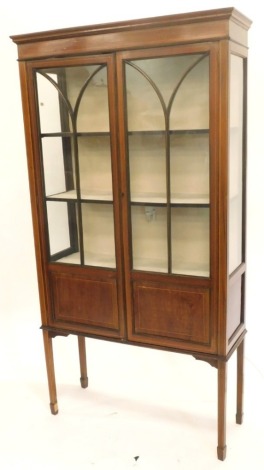 An Edwardian mahogany and boxwood strung display cabinet, with two glazed doors on square tapering legs, 170cm high, 90cm wide, 32cm deep.