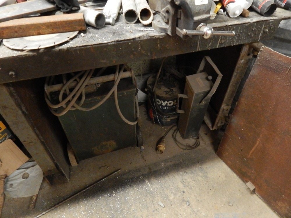 A welding station, including bench with two vices, portable welder