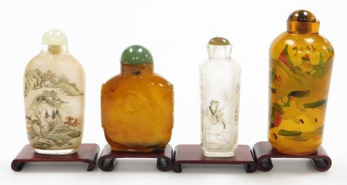 Four Chinese snuff bottles and stoppers, and two clear glass bottles, decorated with landscapes, one amber glass inside painted bottle with warriors and an agate bottle carved in low relief with Putai and mock mask ring handles, with stands, 7cm and 9.5cm