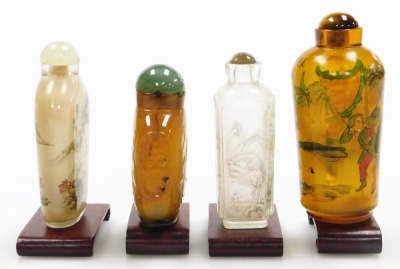 Four Chinese snuff bottles and stoppers, and two clear glass bottles, decorated with landscapes, one amber glass inside painted bottle with warriors and an agate bottle carved in low relief with Putai and mock mask ring handles, with stands, 7cm and 9.5cm - 2