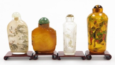 Four Chinese snuff bottles and stoppers, and two clear glass bottles, decorated with landscapes, one amber glass inside painted bottle with warriors and an agate bottle carved in low relief with Putai and mock mask ring handles, with stands, 7cm and 9.5cm - 3