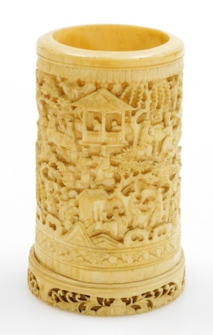 A 19thC Chinese Canton ivory spill vase, of cylindrical form, carved with a panoramic landscape of pagodas, figures and foliage, on an attached pierced circular base, 10.5cm high.