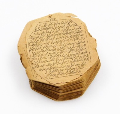 A printed miniature Qur'an, bound with strings, lacking case and possibly incomplete, c.3cm.