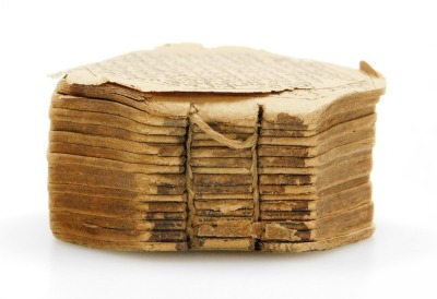 A printed miniature Qur'an, bound with strings, lacking case and possibly incomplete, c.3cm. - 4