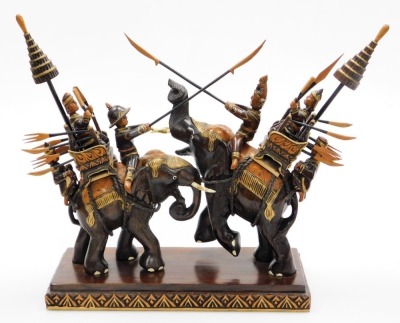 A carved Indian hardwood group of two mounted elephants, two elephants with figures in combat, with wood inlay and gilding, 33cm high, 37cm wide, 15cm deep.