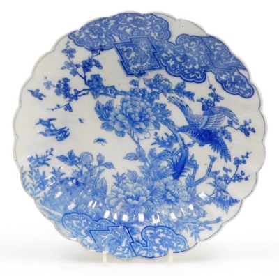 A Japanese early 20thC transfer printed blue and white fluted dish, decorated with birds, flowers and blossom, 31cm diameter, together with a Chinese blue and white tea bowl and saucer decorated with vases of flowers, probably 18thC. (3) - 2