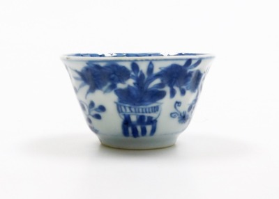 A Japanese early 20thC transfer printed blue and white fluted dish, decorated with birds, flowers and blossom, 31cm diameter, together with a Chinese blue and white tea bowl and saucer decorated with vases of flowers, probably 18thC. (3) - 6