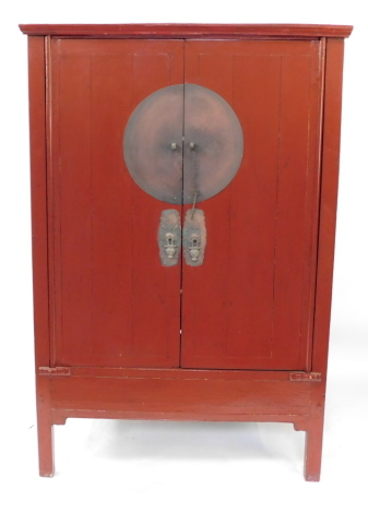 A Chinese 19thC red lacquer marriage cupboard, the outswept pediment over a pair of doors opening to reveal a shelf, above two frieze drawers, with recess below, raised on stile feet, 172cm high, 111cm wide, 61cm deep.