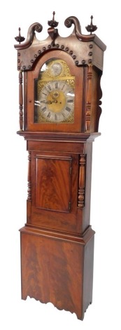 An early 19thC flame mahogany cased long case clock, the brass break arch dial with silver chapter ring bearing Roman numerals, subsidiary seconds dial, eight day two train movement with bell strike, the case hood with broken arch pediment for floral fini