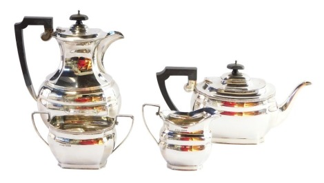 A George VI silver four piece tea and coffee service, each set with ribbed top bordering, on part fluted design with ebonised handles, comprising teapot, coffee pot, cream jug and sugar bowl, Sheffield 1944, 61¼oz gross.