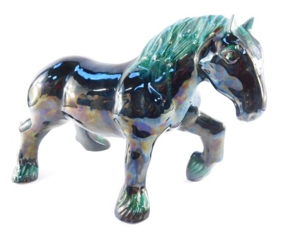 A Blue Mountain pottery figure modelled as a shire horse, in black and green mottled glazing, 31cm high, 42cm wide.