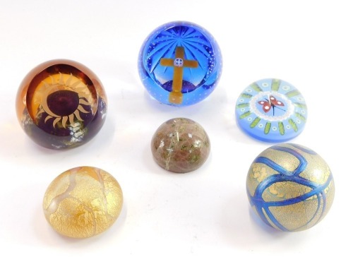 A group of paperweights, comprising a Caithness Millennium Glory limited edition 233/500, William Manson collection butterfly paperweight, Caithness Total Eclipse limited edition 51/200, two Isle of Wight glass paperweights, and a serpentine paperweight.