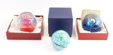 Three paperweights, comprising a Quicksilver domed paperweight, a red and blue Caithness paperweight and another green and blue glittered example unmarked.