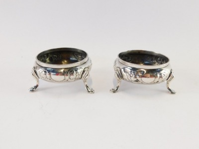 A pair of Victorian silver circular salts, with embossed floral decoration, raised on three hoof feet, Robert Harper, London 1866, 3¼oz. - 2