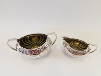 A Victorian silver sugar bowl and cream jug, each semi fluted with chased silver rose detailing and vacant shield, Atkins Brothers, Sheffield 1889, 8¼oz. (2) - 2