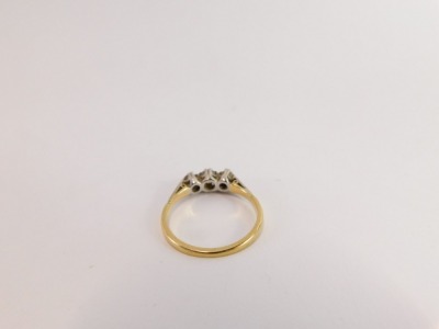 An 18ct gold and platinum three stone diamond ring, set with three old cut diamonds, with platinum claw setting, with Art Deco style shoulders, on a yellow metal band, size P½, 2.6g all in. - 3