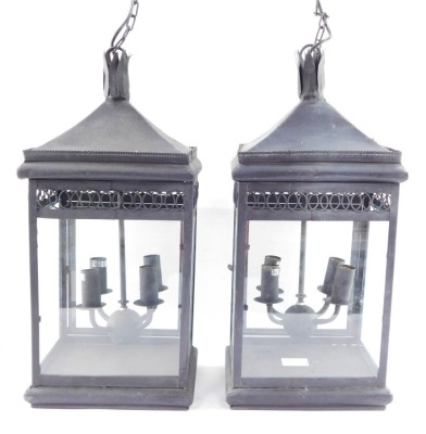 Two wrought iron hanging lanterns, each with four branch central panel, with hanging chain, converted to electricity, 55cm high.