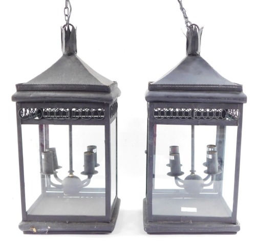 Two wrought iron hanging lanterns, each with four branch central panel, with hanging chain, converted to electricity, 55cm high.