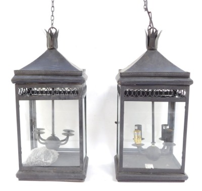 Two wrought iron hanging lanterns, each with four branch central panel, with hanging chain, 55cm high.