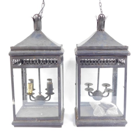 Two wrought iron hanging lanterns, each with four branch central panel, with hanging chain, converted to electricity, 55cm high.