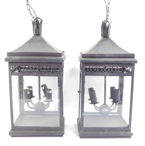 Two wrought iron hanging lanterns, each with four branch central panel, with hanging chain, converted to electricity, 55cm high.